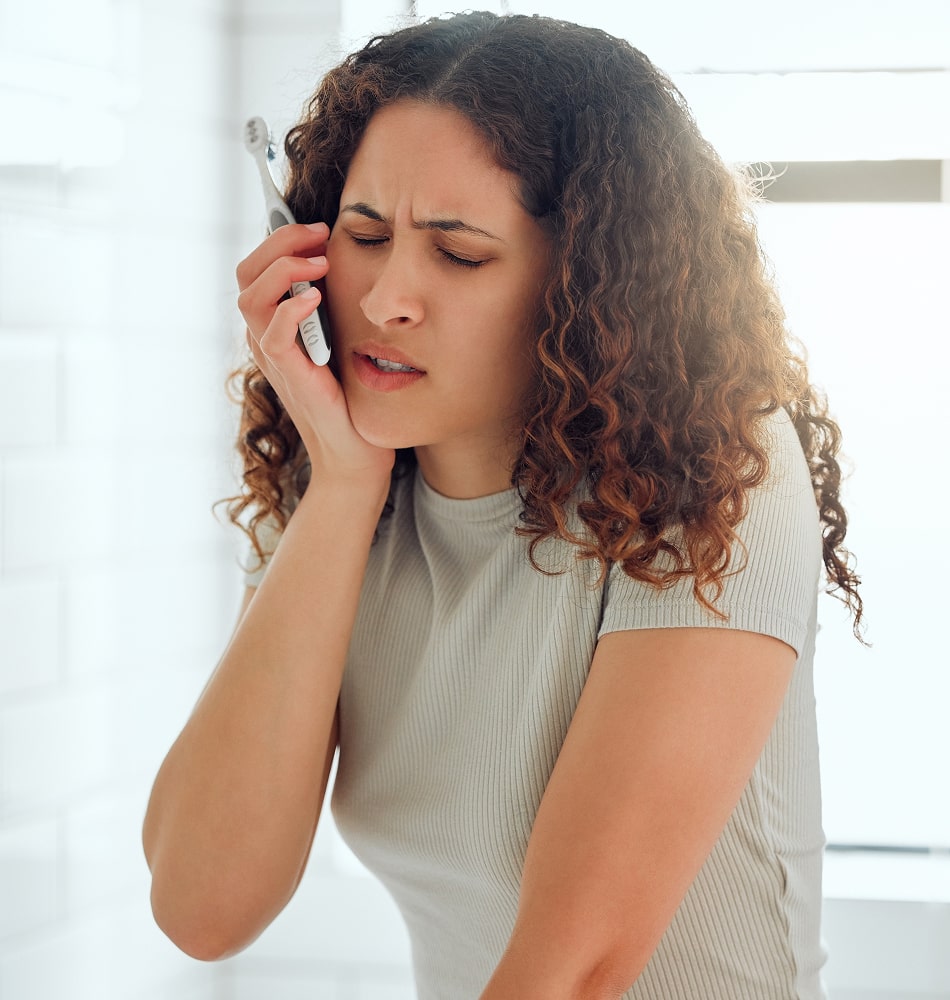 A woman holding her jaw in pain