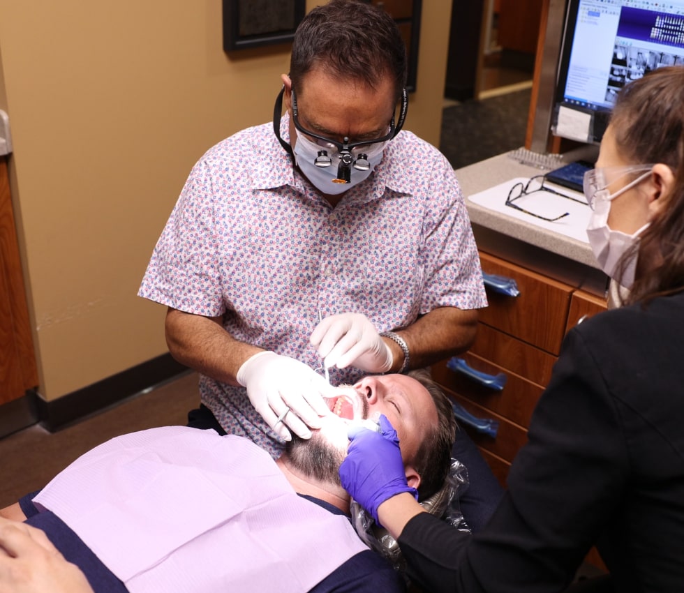 Dr. Ron Sherman with his dental assistant performing dental procedure
