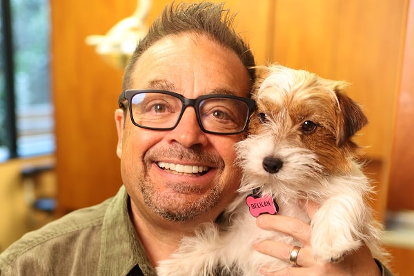 Dr Ron is smiling with therapy dog