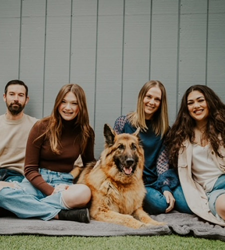 Abby is smiling with her family and dog