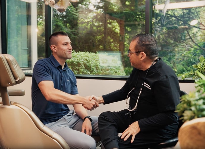 Dr Sherman is shaking hands with his happy patient