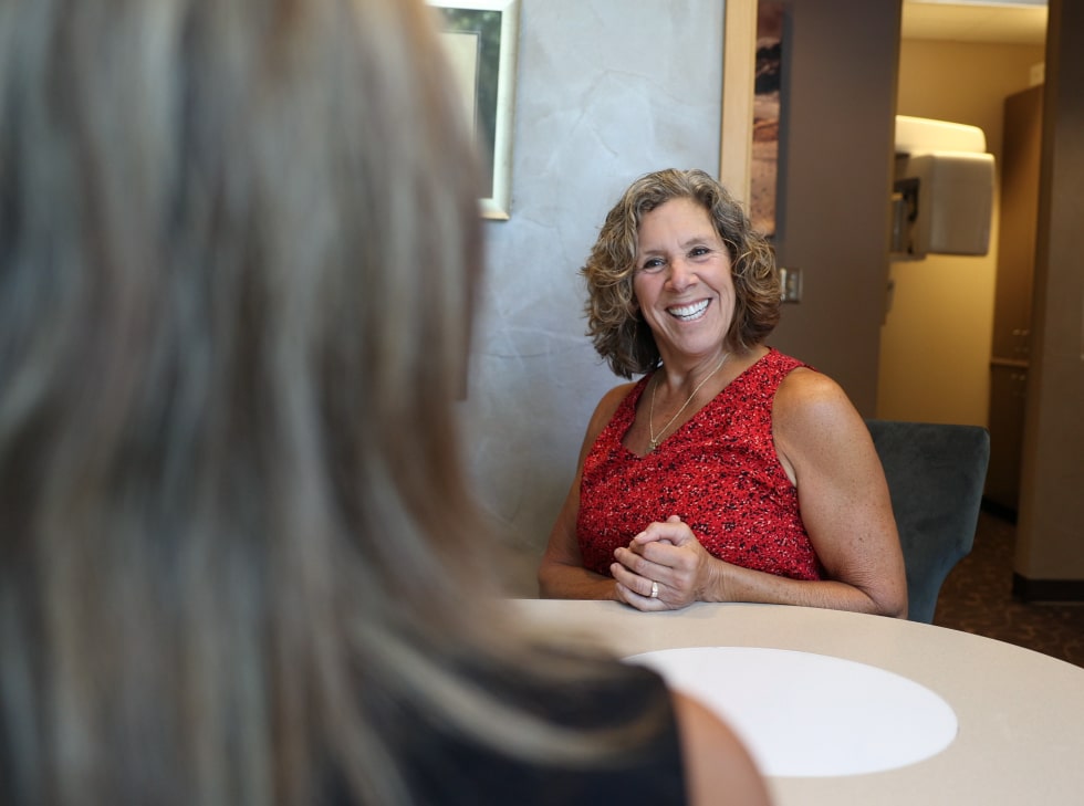 A mature woman smiling after her dental implant treatment